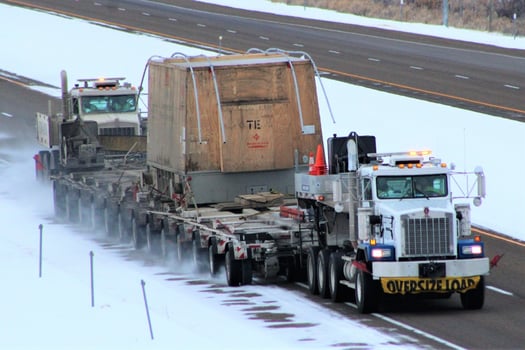 Kenco's oversize load bucket truck services clearing route to Canada.