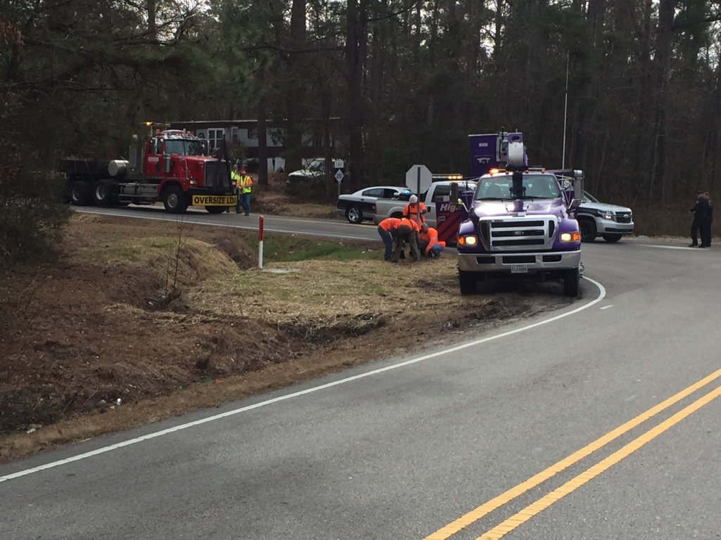 Purple bucket truck company, Kenco, hard at work removing a roadside obstacle.